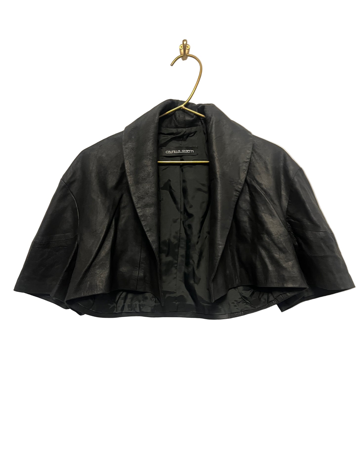 STÆRK black capelet on a beige background